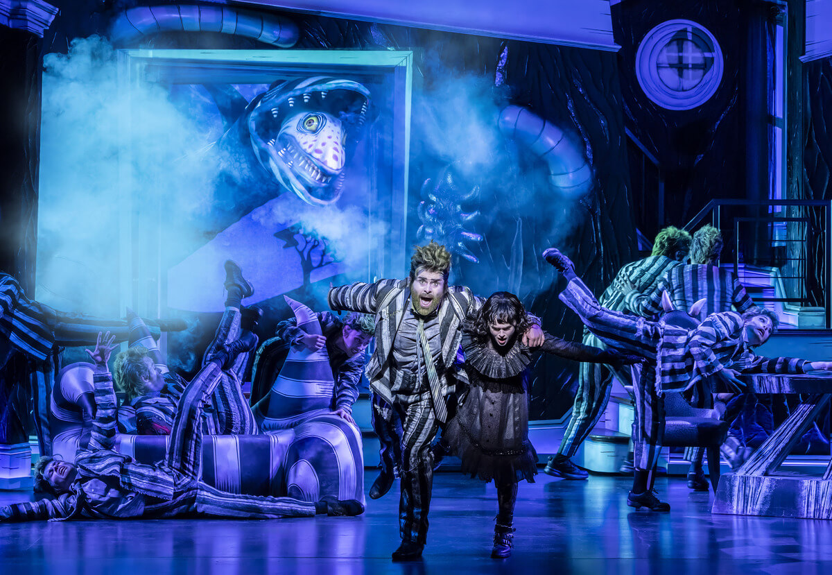 David Fynn som Beetlejuice og Hannah Nordberg som Lydia Deetz med ensemblet © Johan Persson